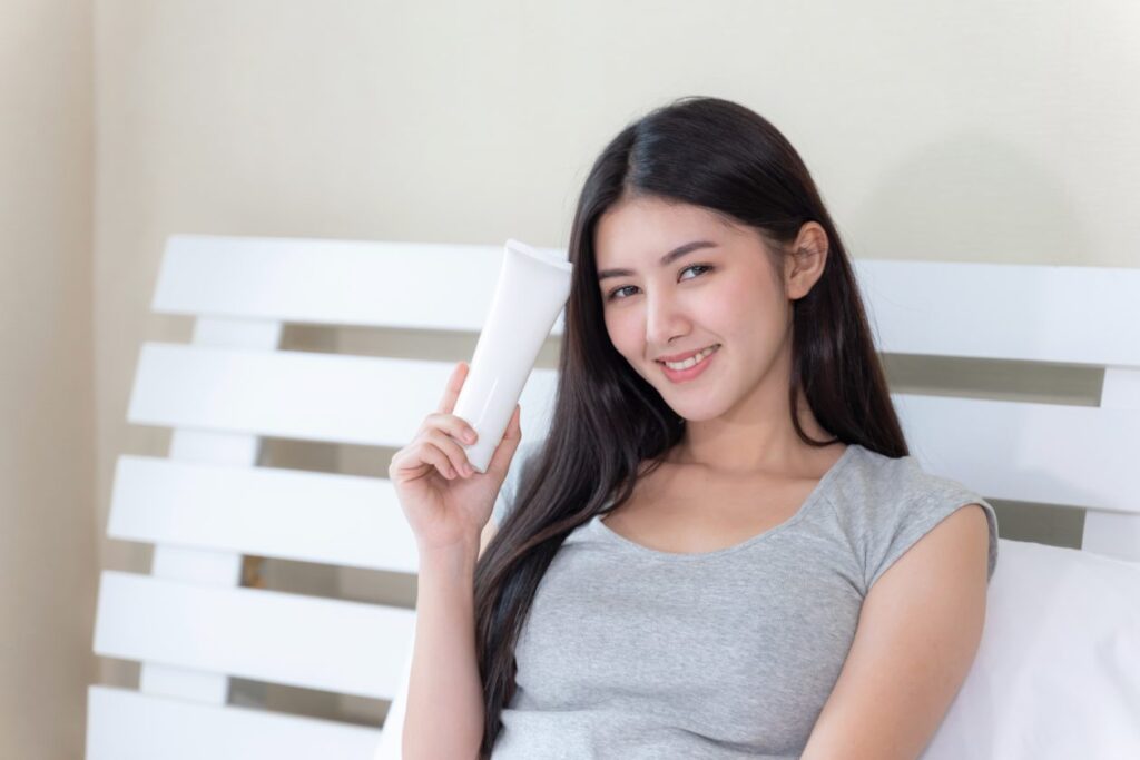 young-beautiful-woman-holding-skin-lotion-her-hand-smiling-with-happiness