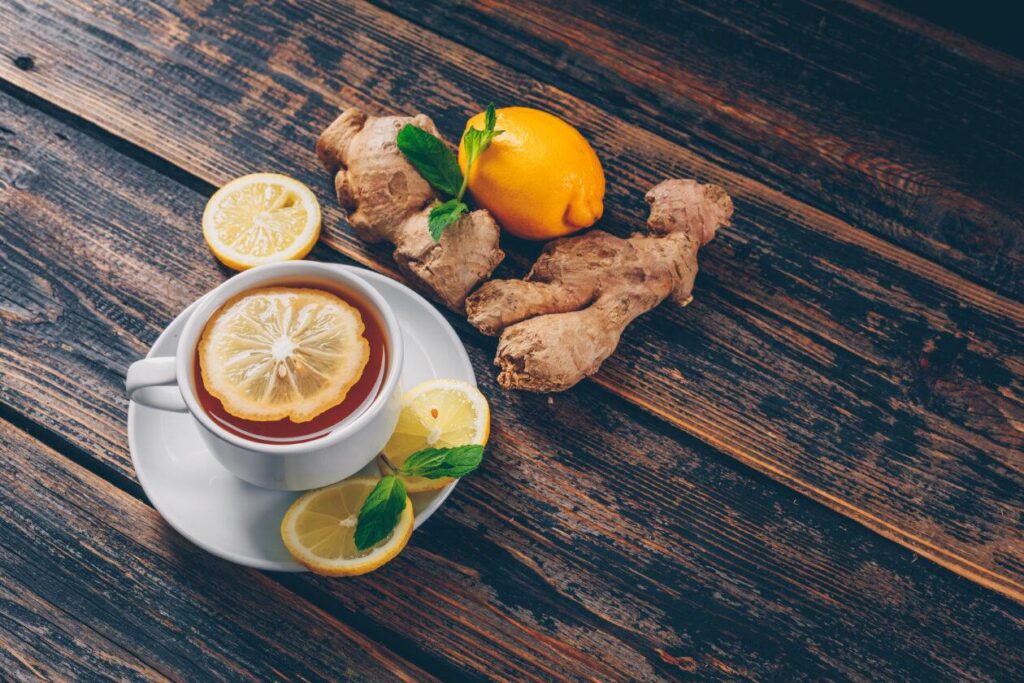 Set of ginger, lemon and a cup of tea on a dark wooden background. high angle view. space for text