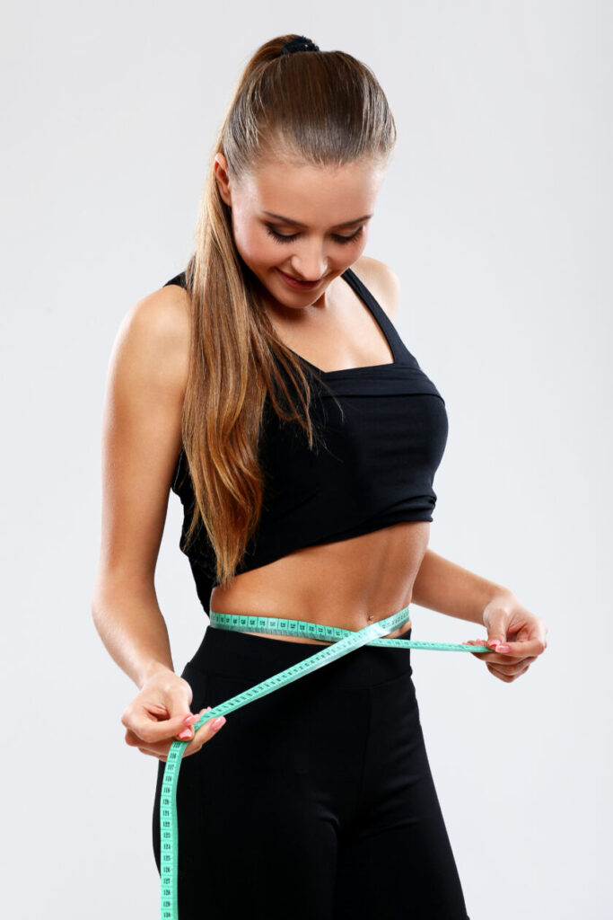 fitness girl measuring her waist